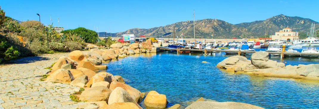 Hafen von Olbia mit grünem Berg im Hintergrund.